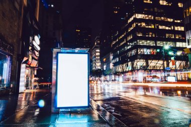 Reklam veya promosyon içeriği için boş kopya boşluk ekranı ile yağmurlu gece otobüs terminali Billboard, bilgi için lightbox kadar boş sahte, uzun pozlama ile kentsel şehir sokakta boş ekran