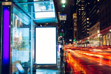 Reklam veya promosyon içeriği için boş kopya boşluk ekranı ile yağmurlu gece otobüs terminali Billboard, bilgi için lightbox kadar boş sahte, uzun pozlama ile kentsel şehir sokakta boş ekran