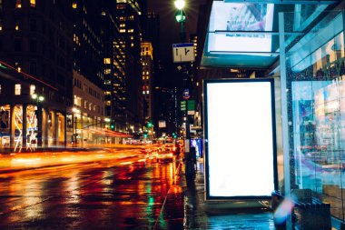 Reklam veya promosyon içeriği için boş kopya boşluk ekranı ile yağmurlu gece otobüs terminali Billboard, bilgi için lightbox kadar boş sahte, uzun pozlama ile kentsel şehir sokakta boş ekran
