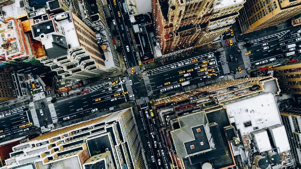 Aerial view of New York downtown building roofs. Bird\'s eye view from helicopter of cityscape metropolis infrastructure, traffic cars, yellow cabs moving on city streets and crossing district avenues