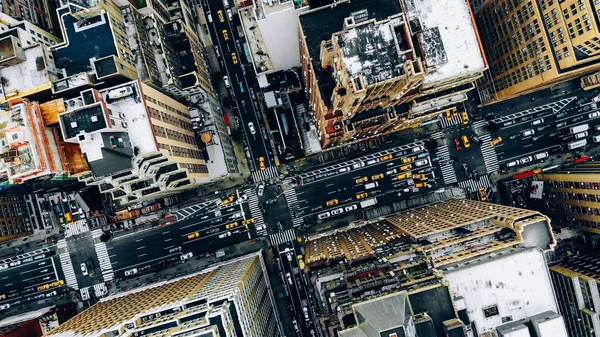 Aerial view of New York downtown building roofs. Bird\'s eye view from helicopter of cityscape metropolis infrastructure, traffic cars, yellow cabs moving on city streets and crossing district avenues