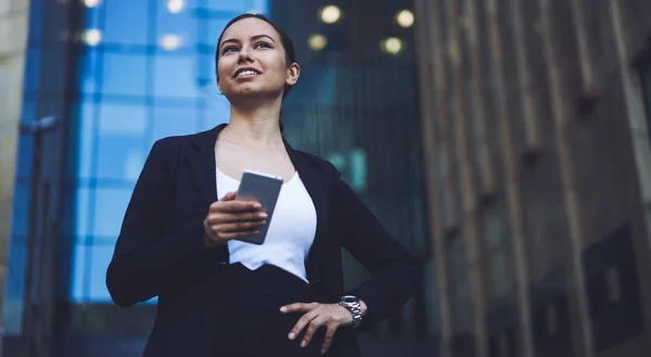 Pozytywna Kobieta Kierownik Tysiąclecia Czuje Się Dobrze Zewnątrz Trzymając Smartfon — Zdjęcie stockowe