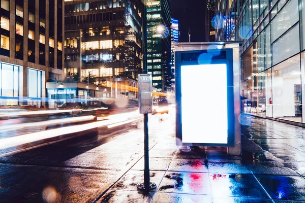 Reklam veya promosyon içeriği için boş kopya boşluk ekranı ile yağmurlu gece otobüs terminali Billboard, bilgi için lightbox kadar boş sahte, uzun pozlama ile kentsel şehir sokakta boş ekran