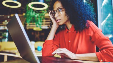 Ciddi Afro Amerikan kitap editörü uzaktan yeni bestseller okuma bölümü ile çalışma ve değişim hakkında düşünme, çekici kadın Freelancer uygulama ayarlarını öğrenmek için Webinar izliyor