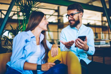 Erkek ve kadın blogcular birlikte toplantı zevk ve akıllı telefon cihazları aracılığıyla sosyal ağlarda takipçileri ile iletişim, iki mutlu hipsters Gadget 'ları kullanarak break birbirleri ile konuşurken