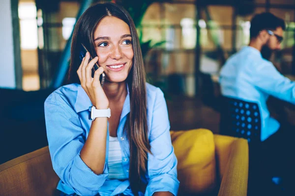 笑顔のヒップスターの女の子カジュアルな服を着てスマートフォンの会話は 仕事から幸せなニュースを受け取った 屋内無線接続を使用してアプリケーションを介して携帯電話の呼び出しを行う肯定的な白人女性 — ストック写真