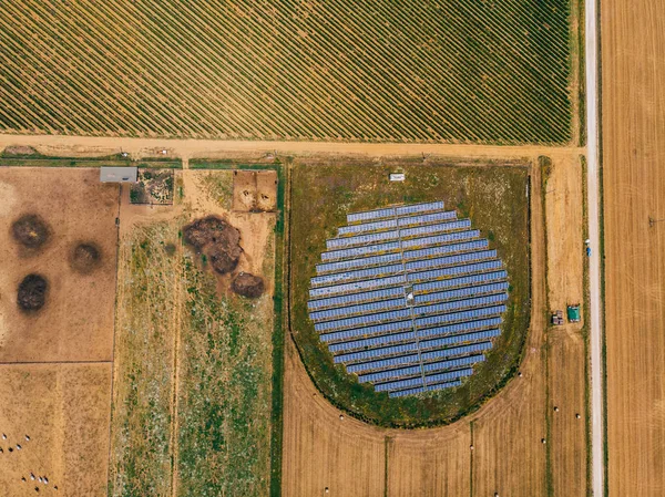 フィールドの近くの農業地域の太陽電池と駅の空中トップビュー 自然環境に有利な代替エネルギー生産システム 革新的なバイオ燃料太陽光発電技術 — ストック写真