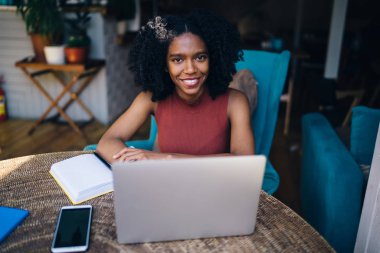 Dizüstü bilgisayar cihazı ile masada oturan çocuk kitapları neşeli yetenekli kadın yazar portre ve olumlu içerik metni oluşturmak için zaman iyi hissediyorum, Netbook ile mutlu hipster kız