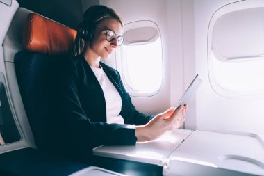Gözlüklerde pozitif kadın, gemide iyi WiFi bağlantısı, uçak ve havayolu kavramı ile birinci sınıftaki Kıtalararası uçuş sırasında arkadaşa online görüntülü görüşme sırasında iyi hissediyor