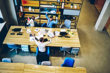 Modern ofis iç toplantı beyin fırtınası sonra başarı ve başarı kutluyor girişimcilerin mutlu grubun üst görünümü. Aşırı sevinçli çalışanlar ekip çalışmasına yönelik iş projesini tamamladı 