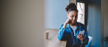 Web sayfasında sohbet sırasında sosyal ağda takipçisi başarılı Afro Amerikan kadın Blogger dinleme sesli mesaj, hücresel üzerinden iletişim için yeni bir uygulama yükleme mutlu genç kadın