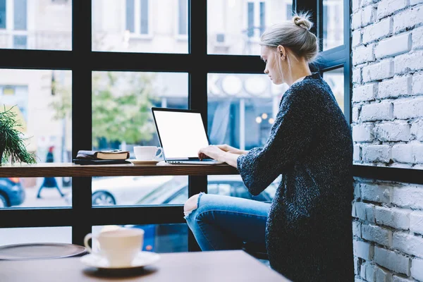 Женщина печатает на ноутбуке в кафе — стоковое фото