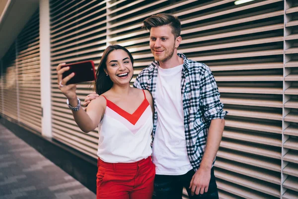 Vrolijk stel neemt selfie in de buurt van modern gebouw — Stockfoto