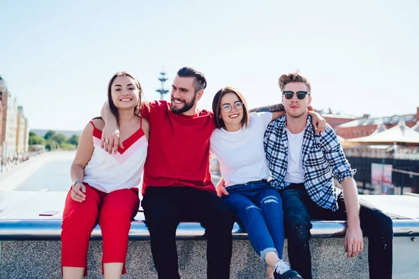 Amigos sonrientes abrazando la frontera en la calle de la ciudad — Foto de Stock