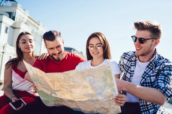 Fröhliche Freunde beim gemeinsamen Kartenlesen — Stockfoto