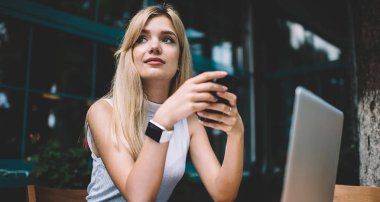 Akıllı telefon ile Dreamy Freelancer uzağa bakıyor