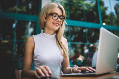 Kafede laptop kullanarak gülümseyen Freelancer