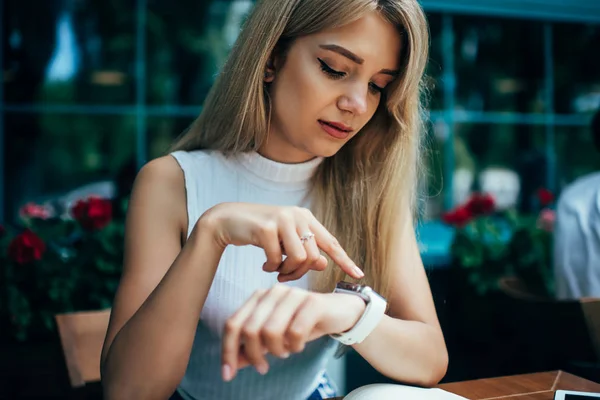 Mujer joven comprobando las notificaciones en smartwatch — Foto de Stock