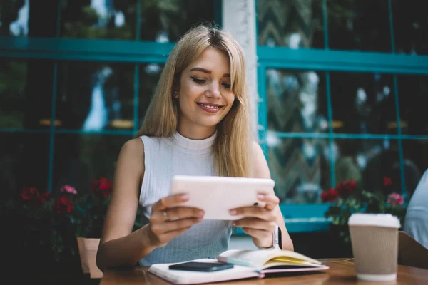 Усміхнена жінка використовує планшет за столом кафе — стокове фото