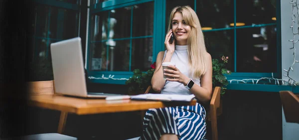 Freelancer con bebida caliente hablando por teléfono durante el descanso — Foto de Stock