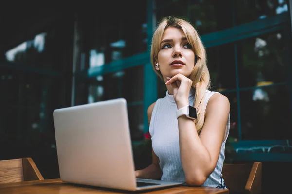 Freelancer pensativo com laptop olhando para longe — Fotografia de Stock