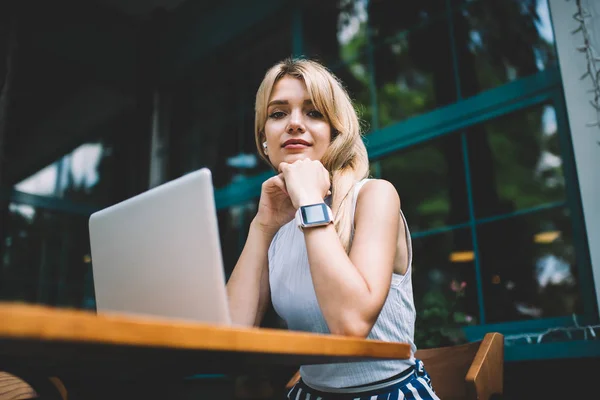 Female freelancer with laptop looking at camera — Stock Photo, Image