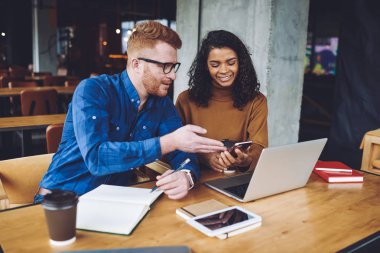 Mutlu gülümseyen erkek ve kadın hipsters okuma kahve dükkanında arkadaşlarıile olay planlama organizasyonu sırasında modern akıllı telefon gadget üzerinden e-posta aldı, teknoloji ve iletişim kavramı