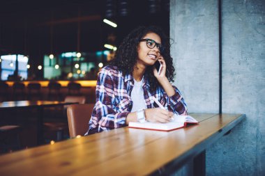 Pozitif kadın öğrenci hücresel Gadget 4g internet bağlantısı kullanarak Discus üniversite programı için arkadaşınıza arama, mutlu hipster kız kolej Kampüsü 'nde öğrenme ve mobil konuşma yapma