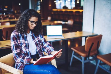 Edebiyat hobi için boş zamanlarında bilgi ders kitabında bilgi araştırma yapan çekici kız öğrenci, üniversite kafede otururken en çok satan okuma genç Afrikalı hipster kız