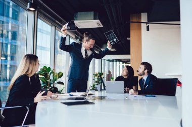 Şirketin erkek patronu çalışanlarla toplantı sırasında belgelerle ilgili sorunları çözüyor, profesyonel girişimciler konferans odasındaki masaüstünde oturuyor ve dinleme yöneticisi--