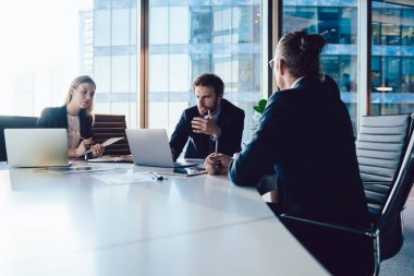 İş projesinde birlikte çalışırken finansal web sitesinden bilgi kontrol eden ciddi deneyimli uzmanlar, kablosuz bilgisayara bağlı dizüstü bilgisayarda haber okuyan profesyoneller grubu