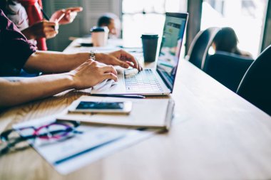 Eş zamanlı çalışma alanındaki uzaklık işi sırasında ücretsiz internet bağlantısı kullanan dizüstü bilgisayardaki uygulama üzerinden metin yazarken kesilen erkek el resmi, netbook 'taki IT uzmanları için kurslar