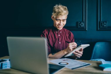 Neşeli Çinli adam kitabı elinde tutuyor ve notlar alırken kağıttan grafikler alıyor. Mutlu gülümseyen Japon hipster öğrenci defterine çizim çiziyor ve dizüstü bilgisayarla modern uzayda oturuyor.
