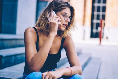 Cep telefonu hesap dengesi ile sorun tartışmak için operatör ile konuşurken moda güneş gözlüğü güzel Kafkas hipster kız, iletişim için gezici bağlantı kullanarak çekici kadın