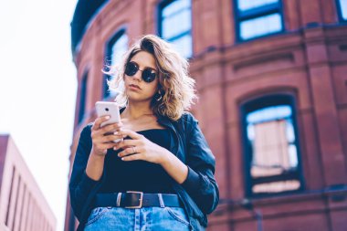 Cep telefonu üzerinde 4g kablosuz internet kullanarak Turizm hakkında içerik makalesi ile güven seyahat Blogger Yayıncılık yayın, telefon uygulama yükleme güneş gözlüğü çekici hipster kız