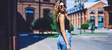 Çekici hippi kızın yarım boy portresi şehir merkezinde yürüyor ve boş zamanlarında uluslararası akıllı telefon konuşmaları yapıyor, genç trend bir kadın kiralık araba için taksi servisini arıyor.