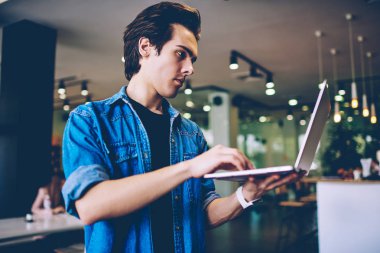 Üniversite kafeteryasında iyi wifi internet arama hotspot bağlantı seçimi Ciddi öğrenci, kendi kafeterya iç dizüstü bilgisayar ile konsantre erkek bin yıllık girişimci iş