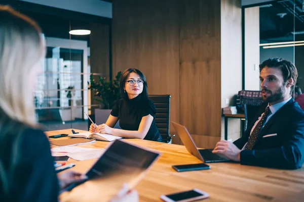 現代のオフィスで働く多様な男性と女性のパートナーがラップトップコンピュータとの会議テーブルで協力し 多文化の同僚が金融戦略のブレインストーミングについて議論 — ストック写真