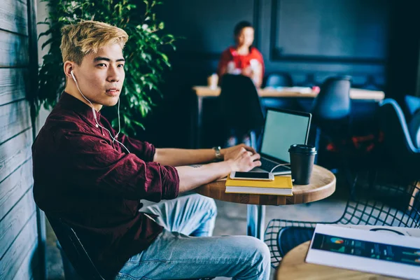 Overveiende Asiatisk Hipster Fyr Elektroniske Hodetelefoner Som Tenker Informasjon Fra – stockfoto