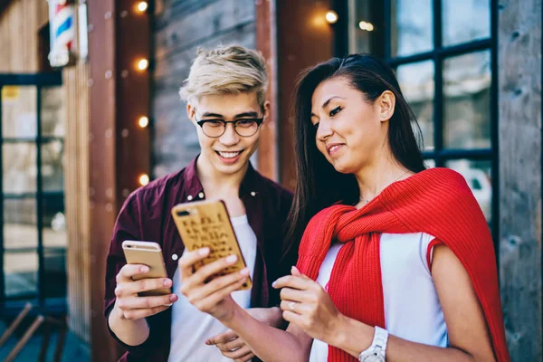 积极微笑的亚洲时尚男人使用蓝牙连接共享多媒体文件在现代智能手机设备上 开朗的男人和女人看有趣的视频在线社交网络 — 图库照片