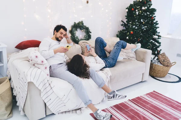 stock image millennial hipster girl and guy ignore communication resting on weekends during winter holidays at home, couple in love addicted to gadgets and social networks browsing staying silent