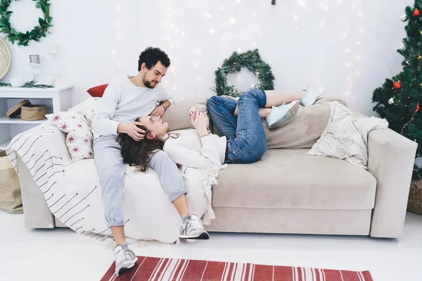 Beyaz erkek, Noel ve kış tatillerinde sevimli kız arkadaşına bakıyor. Romantik genç evli çift, şenlikli apartman dairesinde dinleniyor.