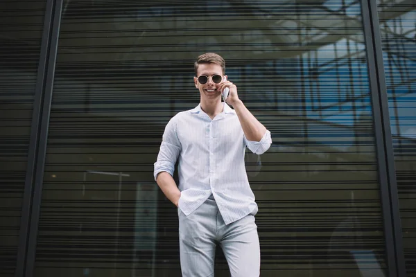 Smiling Slender Male Sunglasses Casual Wear Hand Pocket Conversing Cellphone — Stock Photo, Image