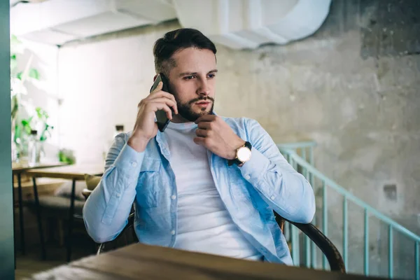 Alvorlig Skjeggete Mann Blå Skjorte Som Snakker Smarttelefon Mens Han – stockfoto