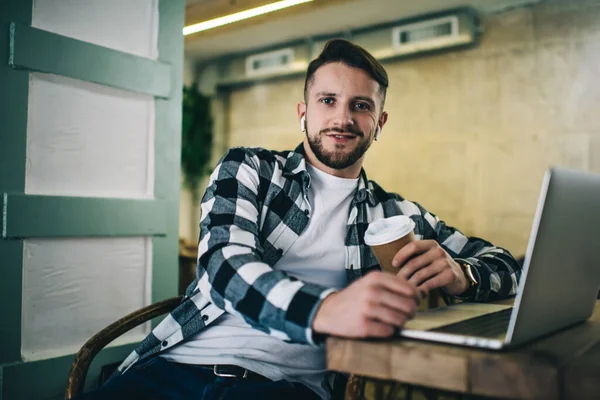 Mann Trendigen Karierten Hemd Sitzt Tisch Mit Heißgetränk Und Netbook — Stockfoto