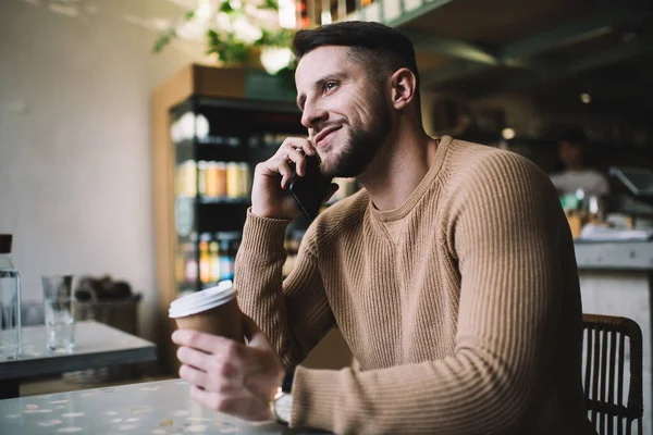 카리스마적 일상적 남자가 스마트폰으로 이야기하고 카페에 앉아서 커피를 — 스톡 사진