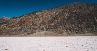 Güneşli kış günlerinde, yüksek görkemli dağların yanında karlı arazisi olan muhteşem beyaz çöl.