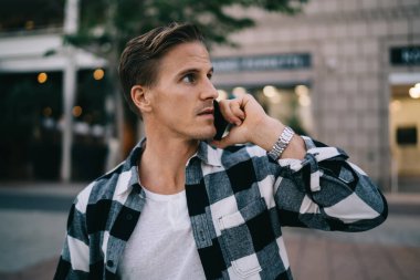 Ciddi, 20 'li yaşlarda, modaya uygun giyinen, cep telefonuyla konuşan, açık havada takılan yakışıklı hippi, akıllı telefondan sokak bağlantıları ve tarifeleriyle konuşan,