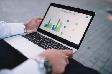 İşletme geliri hakkında çevrimiçi finans raporu hazırlamak için dizüstü bilgisayar kullanan erkeğin kırpılmış görüntüsü, iş adamı Netbook üzerinde çalışırken istatistik gelirleri için grafik şemalarını analiz ediyor