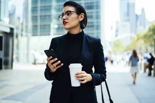 Σοβαρή Νεαρή Επιχειρηματίας Κομψό Ντύσιμο Και Γυαλιά Κρατώντας Smartphone Και — Φωτογραφία Αρχείου